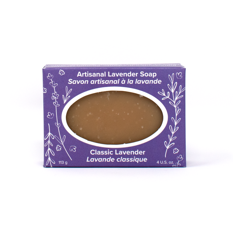 A taupe-coloured bar of soap in a bright purple box with white line drawings of lavender sprigs and flowers. Text reads Artisanal Lavender Soap (Classic Lavender)