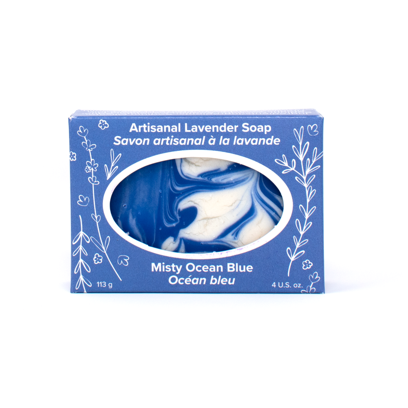 A marbled blue and white bar of soap in a cornflower blue box with white line drawings of lavender sprigs and flowers. Text reads Artisanal Lavender Soap (Misty Ocean Blue)